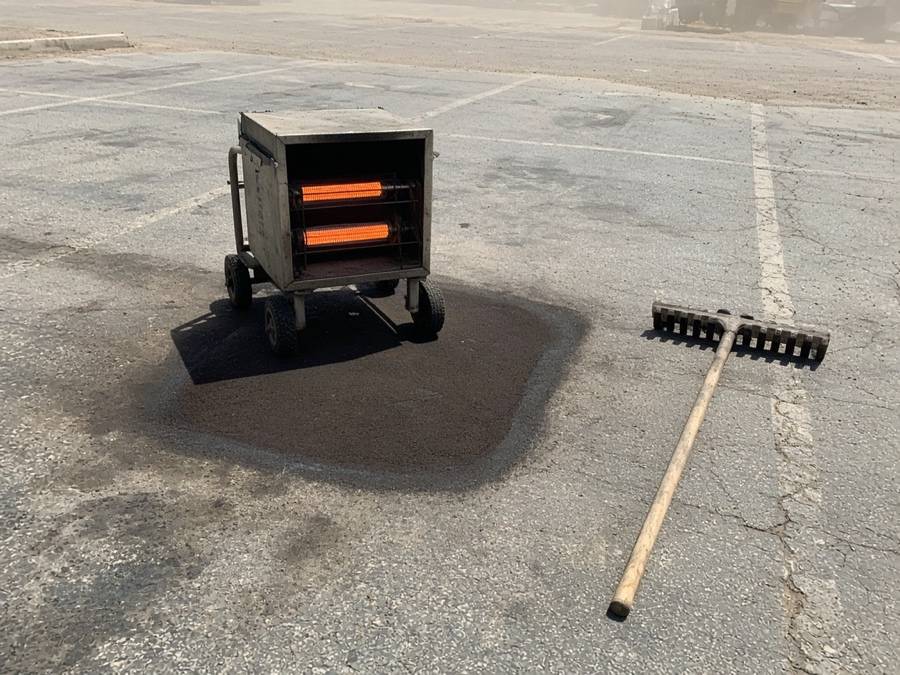 Infrared heater softening an asphalt patch — asphalt paving in Riverside, CA